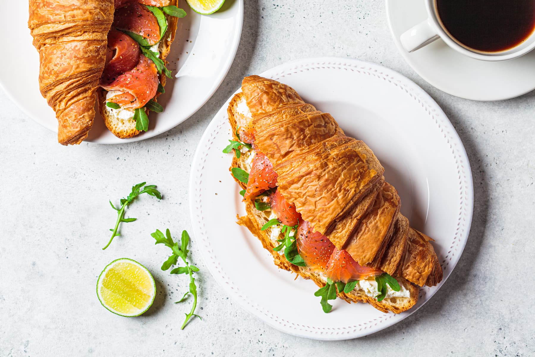 Croissant sandwich with cream cheese salmon on plate.